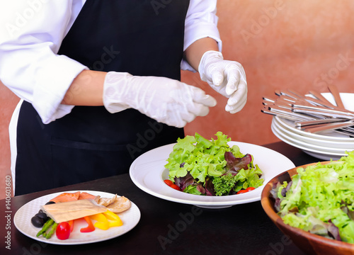 Fototapeta Naklejka Na Ścianę i Meble -  Chef Decorating Salad bowl