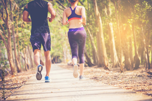two young people running together on road. Man and woman jogging outdoors.