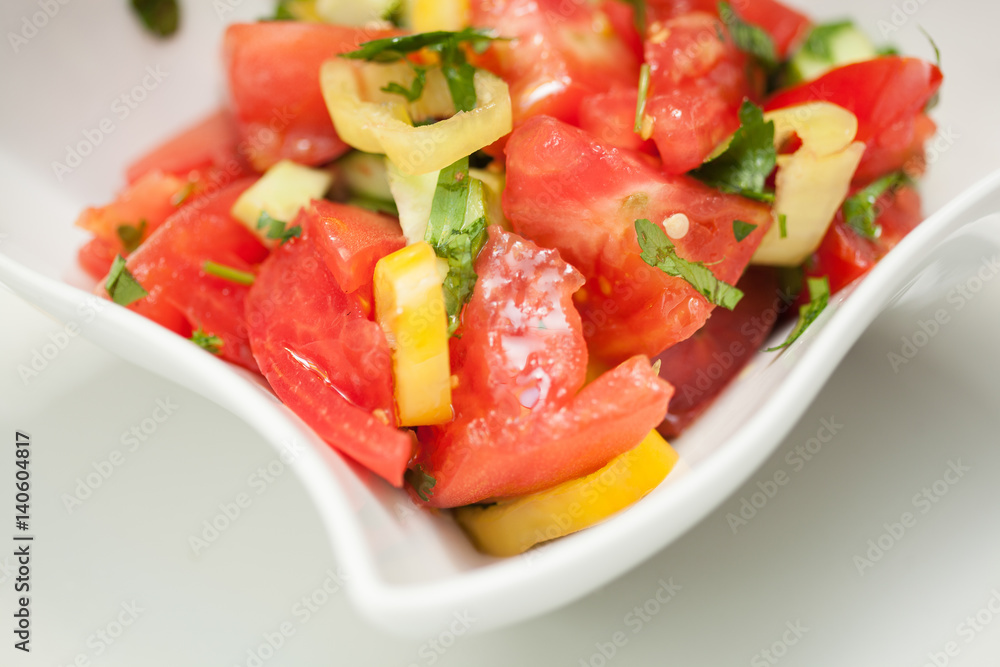 Mixed vegetable salad in a white bowl on white background Mixed vegetable salad in a white bowl on white background