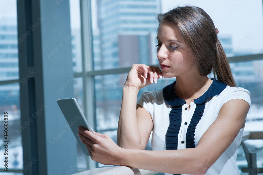 Obraz premium Pensive businesswoman reading from digital tablet
