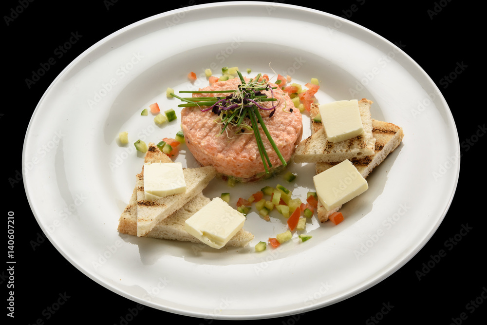 Fresh tartar with salmon, cucumber  on white plate,