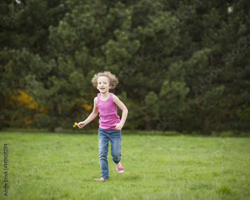 Young girl running through park in summer