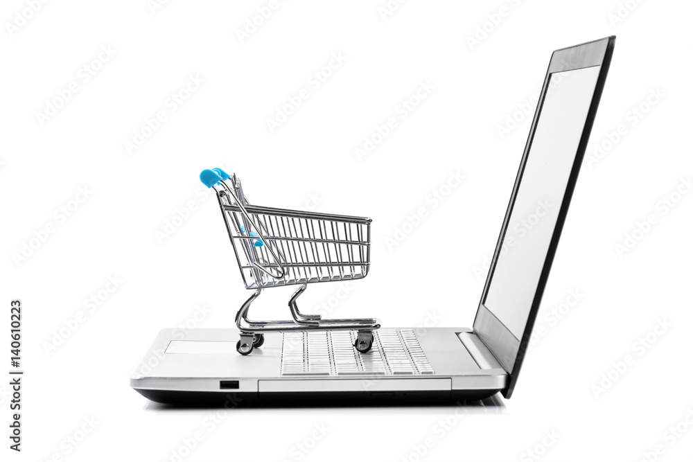 internet store concept - shopping cart on laptop keyboard
