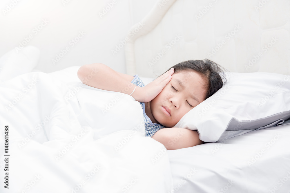 Child lying down suffering from a headache Child lying down suffering from a headache