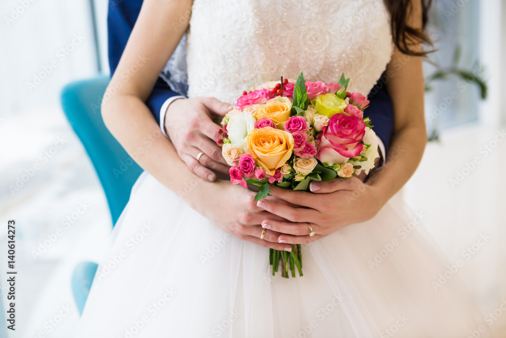 Bouquet of roses in hands of the bride