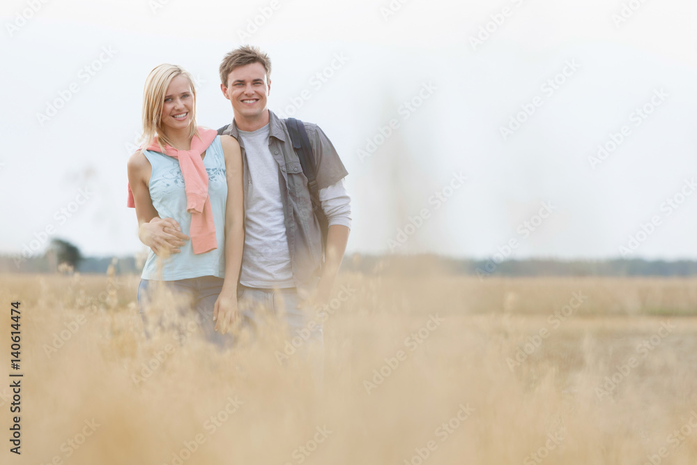 Obraz premium Happy young couple standing at field