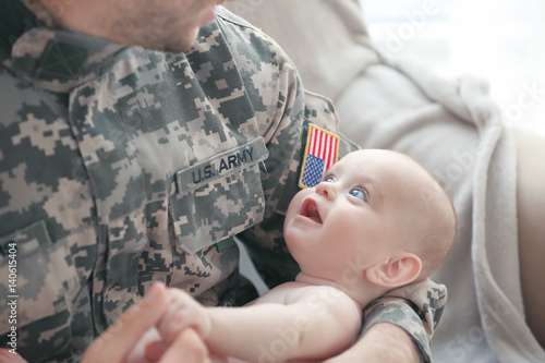 Military father holding his...