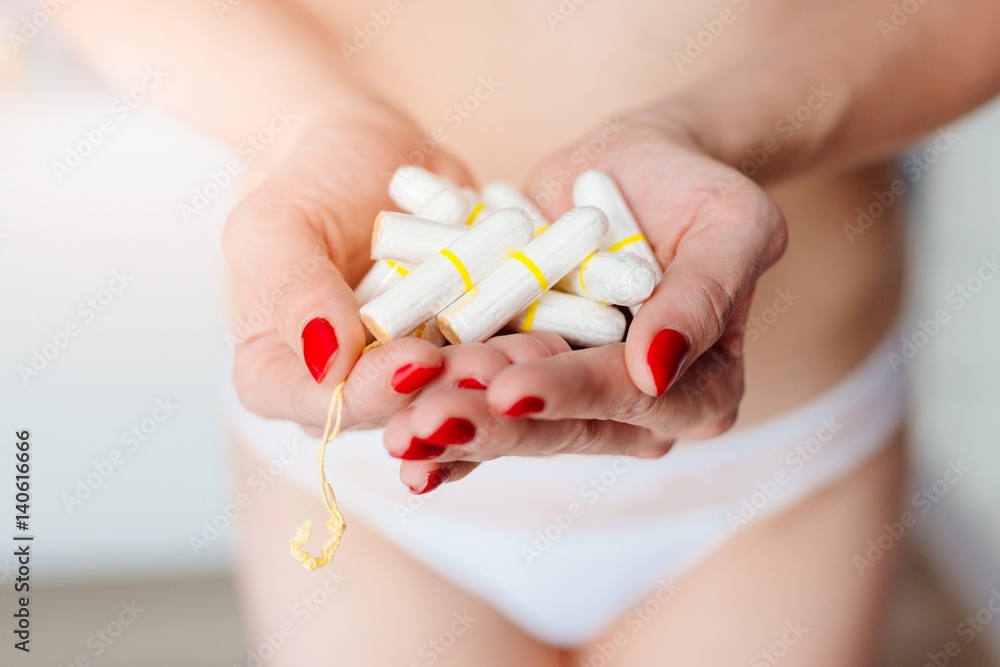 Close up on woman holding white cotton tampons Close up on woman holding white cotton tampons