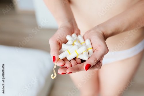 Close up on woman holding white cotton tampons