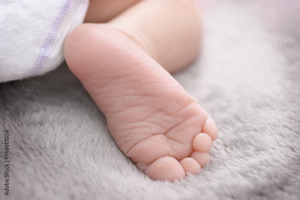 Foot of cute baby lying on bed, closeup Foot of cute baby lying on bed, closeup