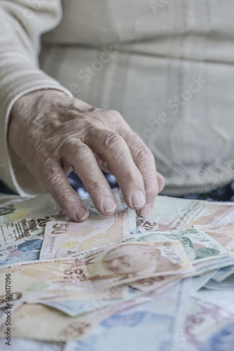 Closeup of wrinkled hand on turkish lira banknotes