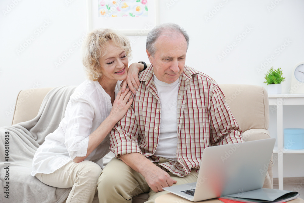 Happy senior couple using laptop at home Happy senior couple using laptop at home