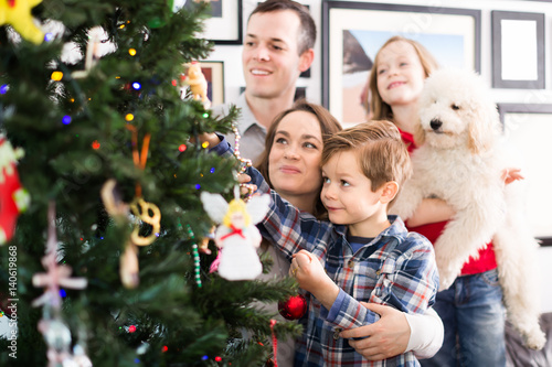 Cheerful family members decorates Christmas tree