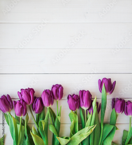 many purple tulips on wooden table