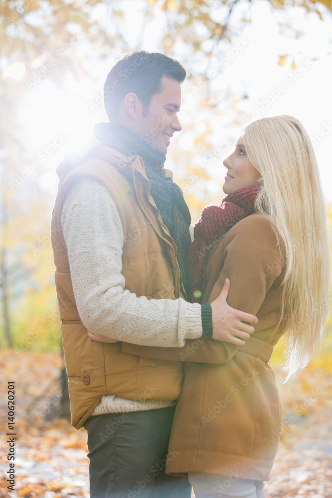 Fototapeta premium Side view of couple hugging in park
