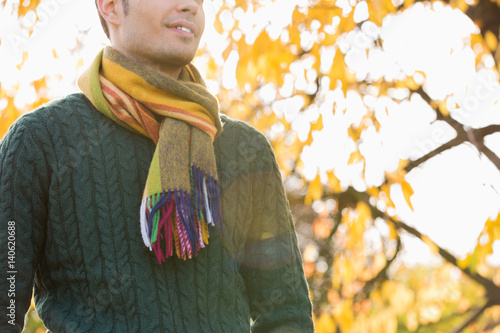 Obraz na płótnie Midsection of man wearing sweater and muffler in park during autumn