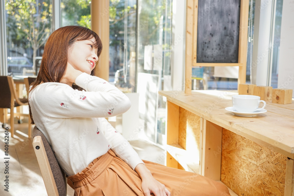 カフェでリラックスする若い女性 カフェでリラックスする若い女性