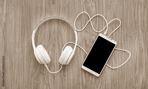 headphones and smartphone on wooden background