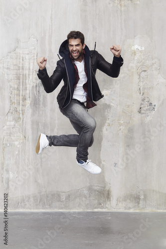 Guy jumping in excitement and success, portrait