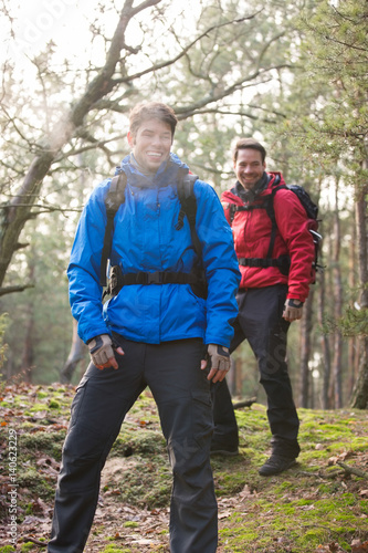 Happy male hikers looking away in forest