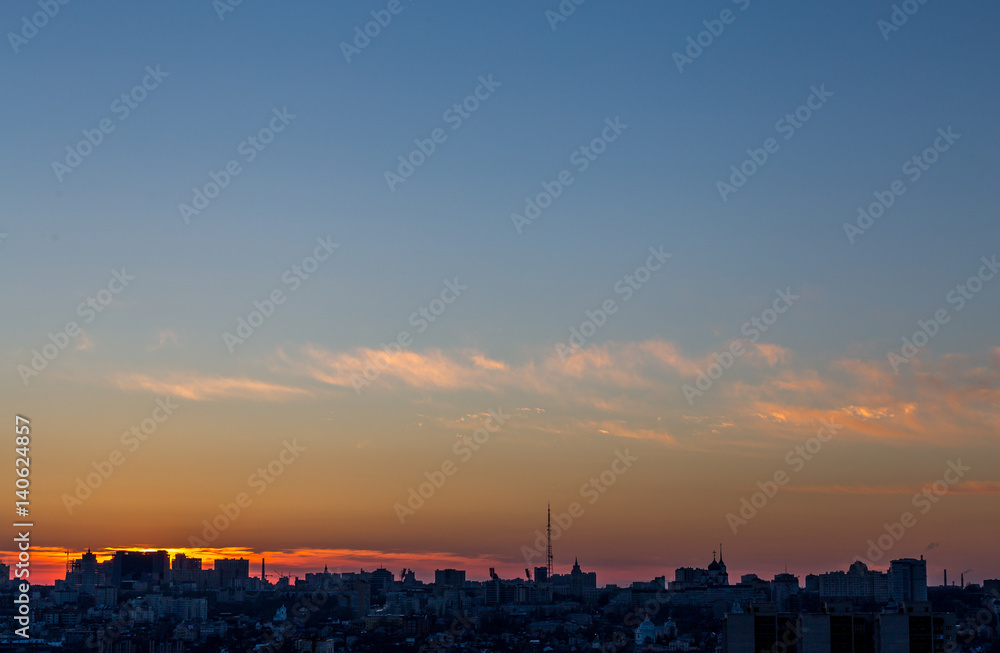City landscape against a dramatic colorful sunset, a lot of copyspace for text, 
