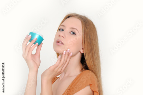 portrait of attractive caucasian smiling woman isolated on white studio applying cream photo