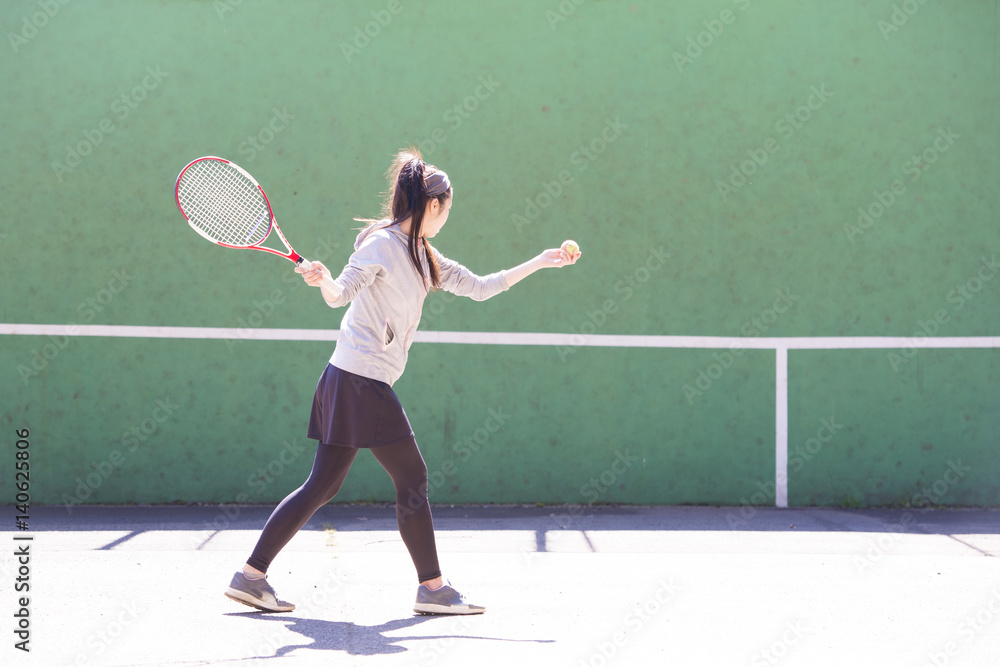 テニスの練習をする女性
