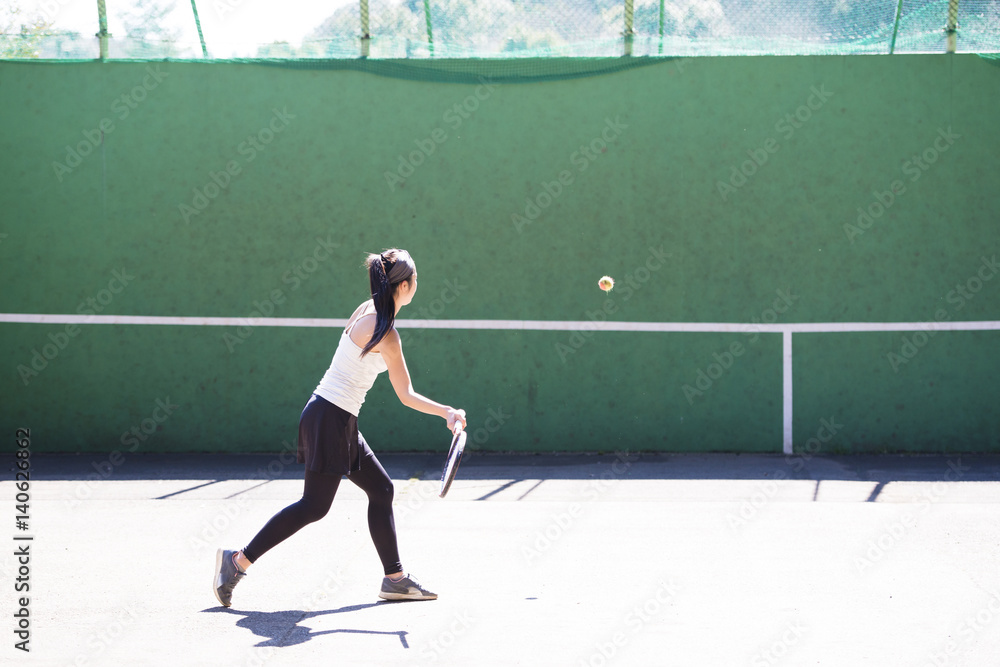 テニスの練習をする女性
