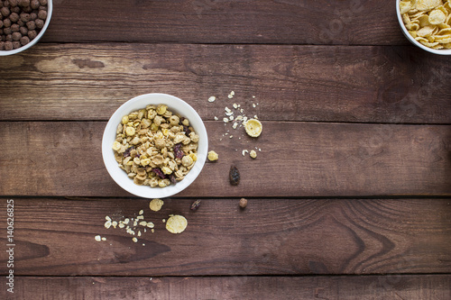 Granola cereal flakes with dried fruit on a wooden table