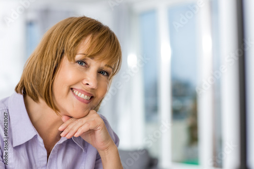 Portrait of happy woman with hand on chin at home © moodboard