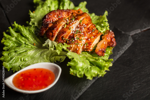Grilled chicken breast with sesame seeds. Sweet and sour sauce. Restaurant
