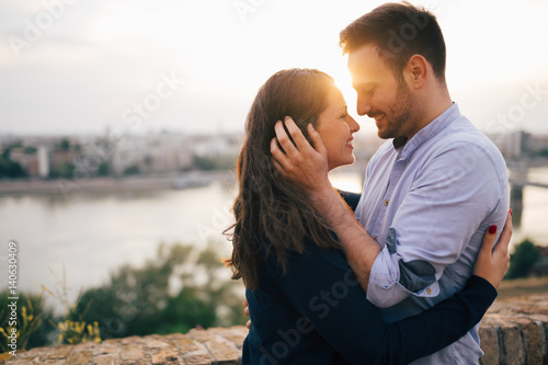 Fotografie Romantic couple cuddling and kissing outdoors