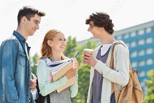 Happy university students conversing at campus