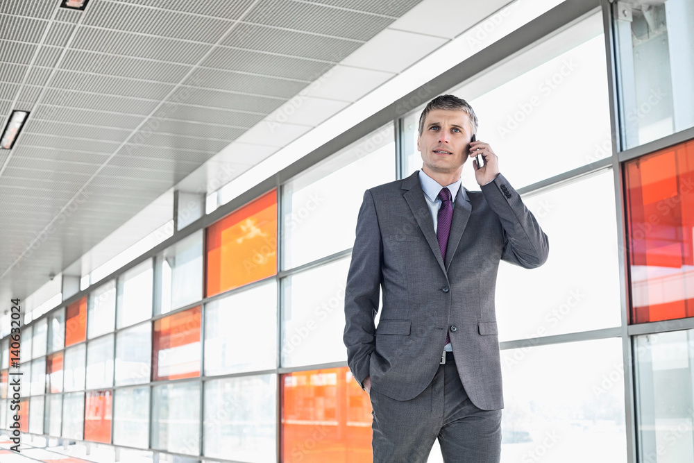 Middle aged businessman using cell phone at train station Middle aged businessman using cell phone at train station
