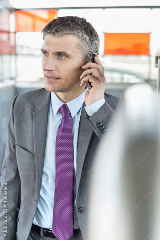 Middle aged businessman using cell phone at train station Middle aged businessman using cell phone at train station