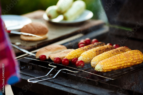 Corn, tomatoes on grill. Barbecue party.