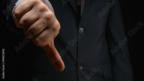 Businessman show a gesture DISLIKE by hand