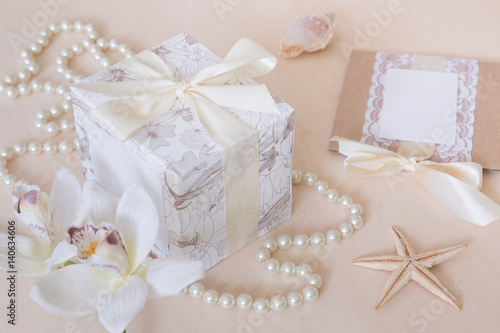 Present, beads, seashells, orchid on wooden background