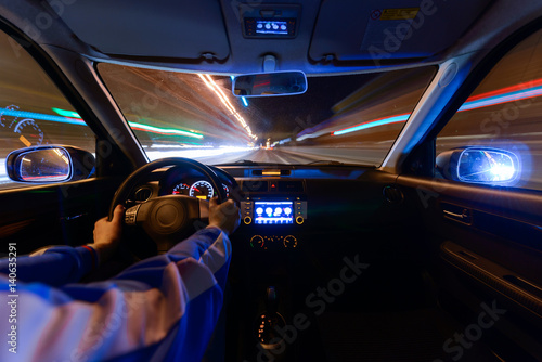 Night road view from inside car natural light street and other cars is motion blurred
