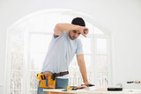 Mid-adult carpenter wiping his brow in new house