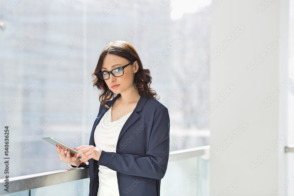 Portrait of confident businesswoman using tablet PC in office Portrait of confident businesswoman using tablet PC in office