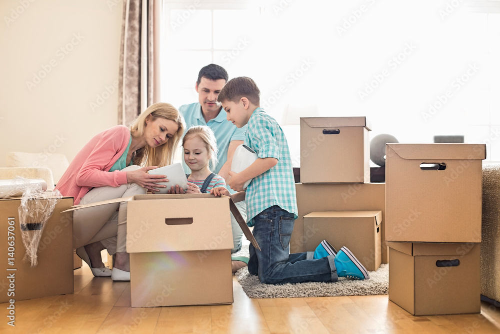 Family unpacking cardboard boxes at new home Family unpacking cardboard boxes at new home