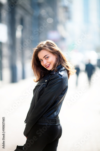 Close up fashion street stile portrait of pretty girl in fall casual outfit walking in city.