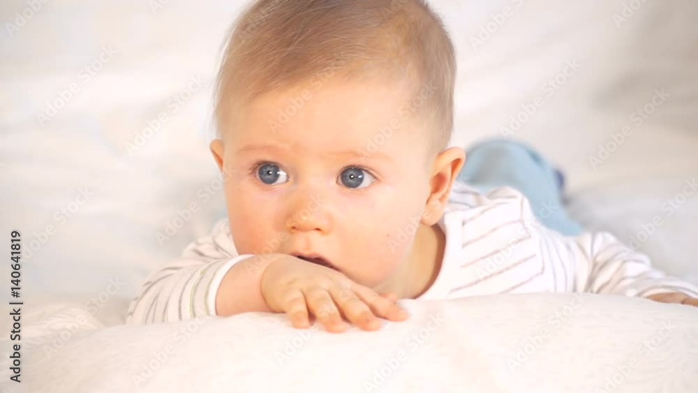 baby mit großen blauen augen und blonden haaren im bett baby mit großen blauen augen und blonden haaren im bett