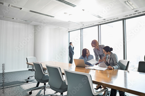 Businesswomen looking at documents in conference meeting