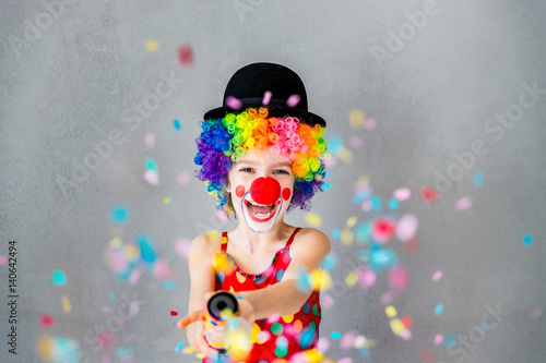 Photo Funny kid clown playing indoor