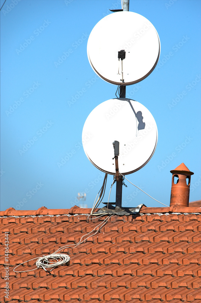 Satellite dishes on a tiled roof Satellite dishes on a tiled roof