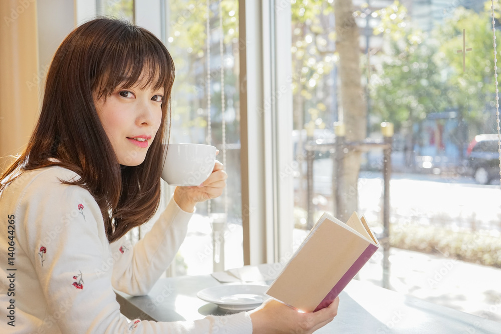 カフェで読書をする若い女性 カフェで読書をする若い女性