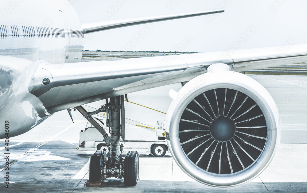 Szczegóły skrzydła silnika samolotu przy bramie terminala przed startem - koncepcja podróży Wanderlust na całym świecie z samolotu lotniczego na lotnisku międzynarodowym - Retro kontrastowy filtr z jasnoniebieskimi kolorami <span>plik: #140646019 | autor: Mirko Vitali</span>