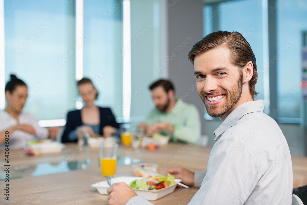 Smiling business executive having meal in office Smiling business executive having meal in office